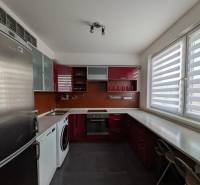 4-izb. byt na ul. Wolkrova, Petržalka, upravený na 2 bytové jednotky - Kuchyňa s červenými skrinkami, spotrebičmi a veľkými oknami v 4-izbovom byte.