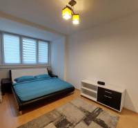 4-izb. byt na ul. Wolkrova, Petržalka, upravený na 2 bytové jednotky - Spálňa v 4-izbovom byte s podlahou s dreveným dekorom, posteľ a polica.