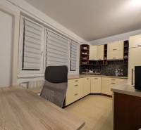 4-izb. byt na ul. Wolkrova, Petržalka, upravený na 2 bytové jednotky - Kuchyňa v 4-izbovom byte s nábytkom, pracovným stolom a podlahou s dreveným dekorom.