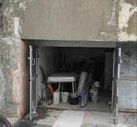 Garáž, Dudvažská ul., Podunajské Biskupice - Garáže na Dudvážskej ulici v Bratislave - Podunajských Biskupiciach s otvorenou bránou a rôznymi predmetmi.