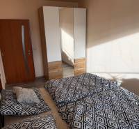 4-izb. byt, Wolkrova, Petržalka, 7.p./8 - Spálňa v 4-izbovom byte s posteľou, šatníkovou skriňou a dverami.