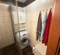 4-izb. byt, Wolkrova, Petržalka, 7.p./8 - Kúpeľňa v 4-izbovom byte s práčkou, sprchovým kútom, uterákmi a košom na bielizeň.