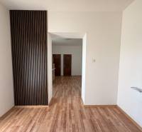 NA PREDAJ rodinný dom v Zemianskej Olči  - Interiér rodinného domu s podlahou s dreveným dekorom a dreveným obkladom na stene.