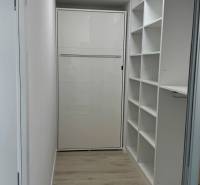 Novostavba 2,5-izb. bytu v NUPPU, garážové státie + vonkajšie státie - Minimalistický úložný priestor v 2-izbovom byte s podlahou s dreveným dekorom.