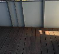 Novostavba 2,5-izb. bytu v NUPPU, garážové státie + vonkajšie státie - Balkón s podlahou s dreveným dekorom a klimatizačnou jednotkou v 2-izbovom byte.