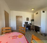 Trojizbový rodinný dom vhodný aj na chalupu v kľudnej časti obce Jatov - Jedáleň v rodinnom dome s dreveným stolom a podlahou s dreveným dekorom.