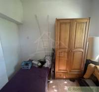 Trojizbový rodinný dom vhodný aj na chalupu v kľudnej časti obce Jatov - Izba v rodinnom dome s posteľou, drevenou skriňou a oknom.