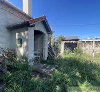 Trojizbový rodinný dom vhodný aj na chalupu v kľudnej časti obce Jatov - Zarastený dvor rodinného domu v Jatove s dreveným skladom palivového dreva.