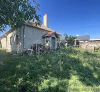 Trojizbový rodinný dom vhodný aj na chalupu v kľudnej časti obce Jatov - Rodinný dom v Jatove s trávnatým dvorom a drevenou hromadou vedľa domu.