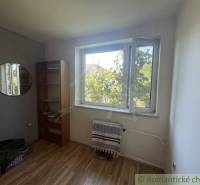 Trojizbový rodinný dom vhodný aj na chalupu v kľudnej časti obce Jatov - Izba v rodinnom dome s podlahou s dreveným dekorom, oknom a regálom.