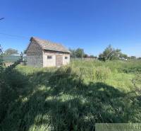 Trojizbový rodinný dom vhodný aj na chalupu v kľudnej časti obce Jatov - Rodinný dom v Jatove obklopený zeleným trávnikom a modrou oblohou.