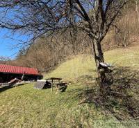 Chalupa - rodinný dom v krásnom prostredí – Moštenica, Banská Bystrica - Chata pri Moštenici obklopená stromami a trávnatými kopcami za slnečného počasia.