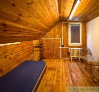 Chalupa - rodinný dom v krásnom prostredí – Moštenica, Banská Bystrica - Interiér chaty s podlahou s dreveným dekorom, posteľ a kreslá pre pohodlie.