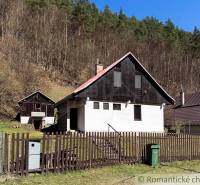 Chalupa - rodinný dom v krásnom prostredí – Moštenica, Banská Bystrica - Chata v Moštenici obklopená lesmi, oplotenie a odpadkový kôš na dvore.