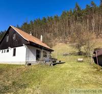 Chalupa - rodinný dom v krásnom prostredí – Moštenica, Banská Bystrica - Chata v Moštenici obklopená trávnatým pozemkom a lesom v pozadí.