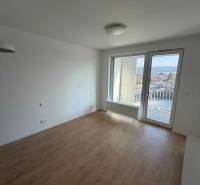 Garzónka v novostavbe AGÁTY, ul. Agátova, Dúbravka, lodžia  - Garsónka s podlahou s dreveným dekorom a balkónovým výhľadom na mesto.