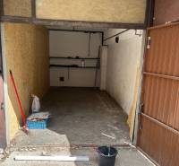 Garáž Rajčianska ul., Vrakuňa - Otvorená garáž na Rajčianskej ulici v Bratislave - Vrakuni s predmetmi na podlahe.