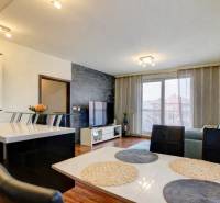 5-izb. byt, Krajinská, Podunajské Biskupice, 2.p./3 - Obývacia izba v 5 a viac izbovom byte s podlahou s dreveným dekorom a jedálenským stolom.