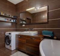 5-izb. byt, Krajinská, Podunajské Biskupice, 2.p./3 - Kúpeľňa v 5 a viac izbovom byte s tmavohnedými obkladačkami a práčkou.