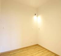 1-izb. byt v novostavbe v Ružinove, 4p./10 - Interiér 1-izbového bytu s bielymi stenami a podlahou s dreveným dekorom.