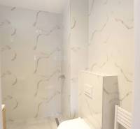 1-izb. byt v novostavbe v Ružinove, 4p./10 - Kúpeľňa v 1-izbovom byte so sprchovacím kútom a toaleta s obkladom v mramorovom dekore.