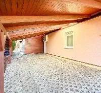 6-izb. rodinný dom, Chorvátsky Grob - Terasa rodinného domu v Chorvátskom Grobe s vydláždenou podlahou a prístreškom.