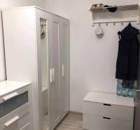 1,5 izb. byt s predzáhradkou, Podunajské Biskupice, projekt Oppidum - V 2-izbovom byte je biely šatník, vešiak a podlaha s dreveným dekorom.