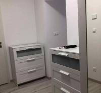 1,5 izb. byt s predzáhradkou, Podunajské Biskupice, projekt Oppidum - Biely nábytok vo vstupnej hale dvojizbového bytu s podlahou s dreveným dekorom.