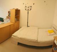 2-izb. byt pri Račianskom Mýte, balkón, 5.p./11 - Spálňa v 2-izbovom byte s dvomi lôžkami, stolom a stenovou výzdobou.