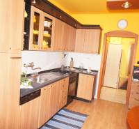 Veľký 1-izb. byt v tehlovom dome, Miletičova ul., Ružinov  - Kuchyňa v 1-izbovom byte so svetlým nábytkom a podlahou s dreveným dekorom.