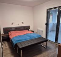 VRSI-MULO - jednoposchodový dom 103,07 m2 len 350 m od mora - Spálňa v Rodinnom dome s podlahou s dreveným dekorom a prístupom na balkón.