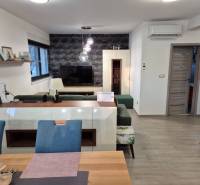 VRSI-MULO - jednoposchodový dom 103,07 m2 len 350 m od mora - Obývacia izba s televízorom, podlaha s dreveným dekorom, sedačka a dekoratívna stena.