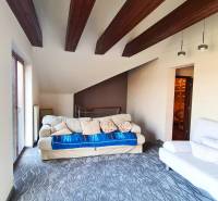 5-izb. dvojpodlažný rodinný dom, Rovinka - Obývacia izba s drevenými trámami a pohovkami v rodinnom dome.