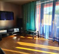5-izb. dvojpodlažný rodinný dom, Rovinka - Obývacia izba v rodinnom dome s plávajúcom podlahou, televízorom a závesmi prepúšťajúcimi svetlo.