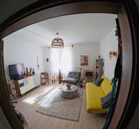 Veľký 2-izb. byt v tehlovom dome, Ružová dolina, Ružinov časť Nivy - Obývačka v 2-izbovom byte s pohodlnou pohovkou, koberecom a podlahou s dreveným dekorom.