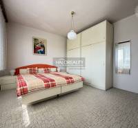 Predaj, rodinný dom Oslany - EXKLUZÍVNE HALO REALITY - Spálňa v rodinnom dome s veľkou skriňou, posteľou a obrazom na stene.