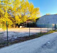 Prenájom oploteného pozemku – Nitra, Mlynárce – 390 m² - Pozemky - komerčné v Nitre, oplotený areál s okolím pokrytým stromami.