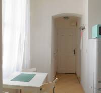 Predaj - štýlový 1,5i byt  v srdci Starého Mesta - Marianska, BA - Jedálenský kút so stolom, stoličkami, bielou stenou a zaveseným svetlom v 2-izbovom byte.