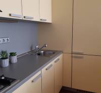 3 izb. byt v úplnom centre pri Šafárikovom námestí - Kuchyňa v 3-izbovom byte s krémovými skrinkami a podlahou s dreveným dekorom.