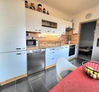 Predaj, trojizbový byt Partizánske, Šípok - EXKLUZÍV... - Kuchyňa v 3-izbovom byte s podlahou s dreveným dekorom a spotrebičmi.