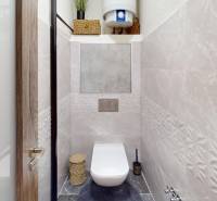 (81 m²) ŠTÝLOVÝ 3i BYT NA SEVERE - Toaleta s béžovými obkladmi a dverami s dreveným dekorom v 3-izbovom byte.