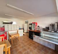 *NA PRENÁJOM* zariadená PIZZA / kebab - Mierová ul. - Interiér gastro priestorov s pultom, chladiacimi vitrínami a stohom krabíc na pizzu.