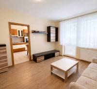 REZERVOVANÝ/ Na predaj 2-izb. byt s balkónom, Senica, Štefánikova ul. - Obývačka v 2-izbovom byte s podlahou s dreveným dekorom a bielymi závesmi.