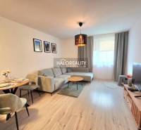 Predaj, dvojizbový byt Bratislava Podunajské Biskupi... - Obývacia izba v 2-izbovom byte s rohovou sedačkou a televízorom, podlaha s dreveným dekorom.