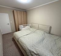 4 Izbový byt na Kríkovej ulici na predaj - Spálňa so sivou posteľou, detskou postieľkou a šatníkovou skriňou v 4-izbovom byte.