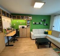 4 Izbový byt na Kríkovej ulici na predaj - Obývacia izba so sedačkou, pracovným stolom a podlahou s dreveným dekorom v 4-izbovom byte.