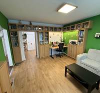 4 Izbový byt na Kríkovej ulici na predaj - Obývacia izba v 4-izbovom byte, s podlahou s dreveným dekorom a knihovňou.