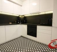 **SKVELÁ INVESTÍCIA**REZIDENCIA OPERA**KÚPELE TURČIANSKE TEPLICE** - Kuchyňa v 2-izbovom byte s čiernobielou dlažbou a modernými spotrebičmi.