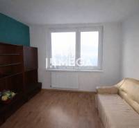 Na predaj veľký 3 izbový byt s balkónom v meste Humenné - Izba v 3-izbovom byte s pohovkou, policami a podlahou s dreveným dekorom.