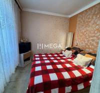 Na predaj 2 izbový byt  na Sokolovskej ulici v meste Humenné - Spálňa so vzorovanou stenou, lôžkom a televízorom v 2-izbovom byte, tapeta s jemným vzorom.